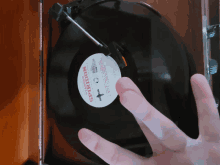 a hand holds a record that says spiriton on the label