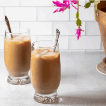 two glasses of iced coffee with spoons on a counter