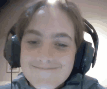 a close up of a person wearing headphones with a smile on their face