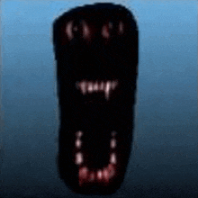 a close up of a black object with a mouth and teeth .