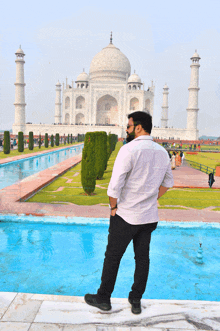 a man standing in front of a large white building