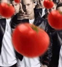 a group of men standing next to each other with tomatoes in their hands .