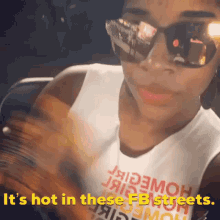 a woman wearing sunglasses and a t-shirt that says it 's hot in these fb streets