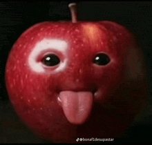 an apple with a face and tongue sticking out .