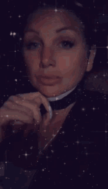a woman with a choker around her neck looks down