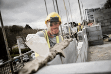 a construction worker wearing a hard hat and safety vest is smiling