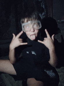 a young boy wearing goggles and a black shirt that says the north face on it