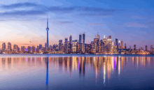 a city skyline is reflected in the water at night