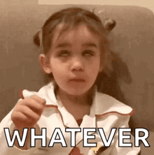 a little girl is making a funny face and the word whatever is on the bottom of her face .