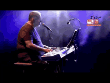 a man is playing a keyboard and singing into a microphone on a screen that says fm 91.9