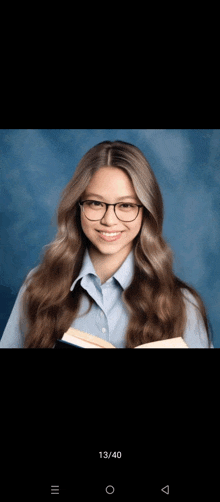 a girl wearing glasses is holding a book and smiling