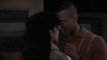 a man and a woman are kissing each other in front of a door .