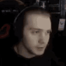 a man is wearing headphones and looking at the camera .