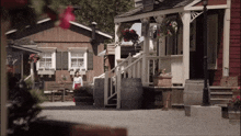 a woman sits on a bench in front of a house with a sign that says ' a ' on it