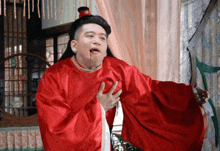 a man in a red robe has blood coming out his mouth