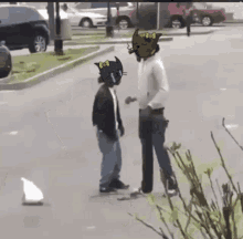 a man with a cat on his head is standing next to another man with a cat on his head