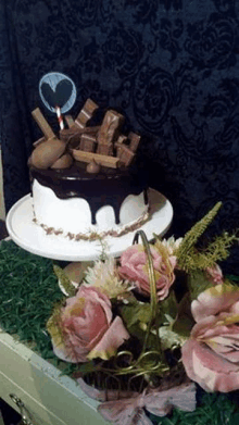 a cake is sitting on top of a cake stand next to a basket of flowers .