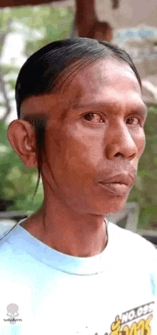 a man with a very long mustache is wearing a white shirt .