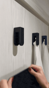 a person hangs a towel on a hook that has the letter u on it