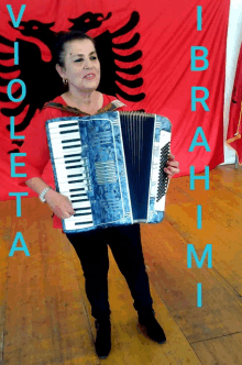 a woman holding an accordion in front of a flag that says viola