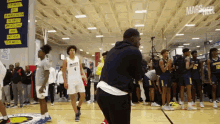 a man taking a picture of a group of basketball players in front of a sign that says mars heel