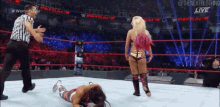 a woman is laying on the ground in a wrestling ring .