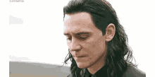 loki from avengers : age of ultron is looking down with a sad look on his face .