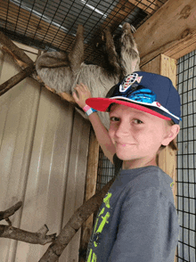 a young boy wearing a hat that says fox on it