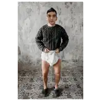 a man wearing a diaper and a sweater is standing in a room