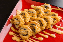 a red plate topped with fried sushi rolls with sauce