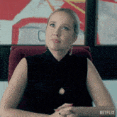 a woman sits in a chair with a netflix logo on the bottom