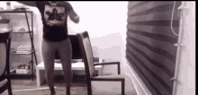 a man in a black shirt is dancing in a living room .