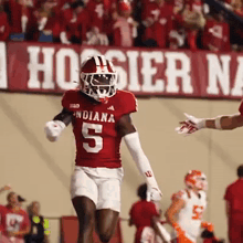 a football player wearing a red jersey with the number 5