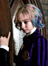 a girl with colorful hair is wearing a purple uniform with the letter n on the back