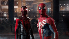 two spider-man costumes are standing next to each other in front of a building .