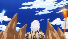 a man with white hair is standing in front of a mountain looking at the sky