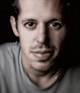 a close up of a man 's face with a gray shirt