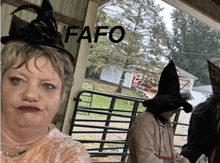 a woman wearing a witch hat is standing in front of a sign that says fafo on it