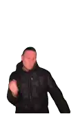 a blurry picture of a man in a black jacket with his fist in the air