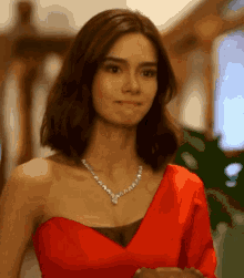 a woman in a red dress with a necklace