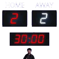 a man stands in front of a scoreboard that says home away