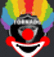 a close up of a clown 's face with a rainbow hairdo and red nose .