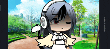 a girl wearing headphones with the letter b on them stands in a park