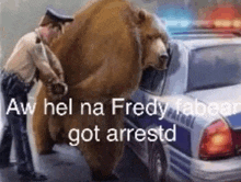 a police officer is standing next to a large brown bear .