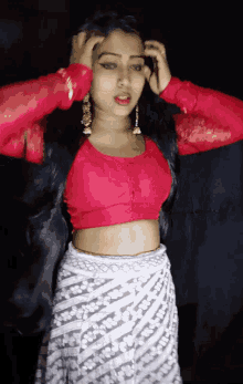 a woman wearing a red crop top and a white striped skirt