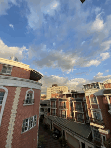 a brick building with a balcony is surrounded by other buildings