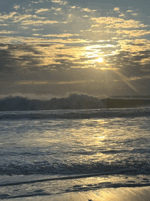 the sun shines through the clouds over a body of water