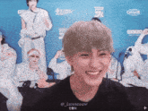 a man in a black shirt is smiling in front of a group of men