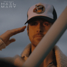 a man wearing a hat that says project hail mary on it