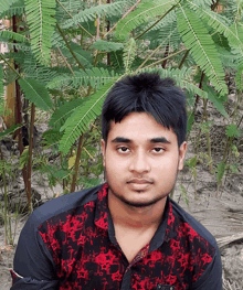 a young man wearing a red and black shirt with a sticker on the sleeve that says ' a '